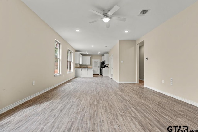 unfurnished living room featuring light hardwood / wood-style floors and ceiling fan