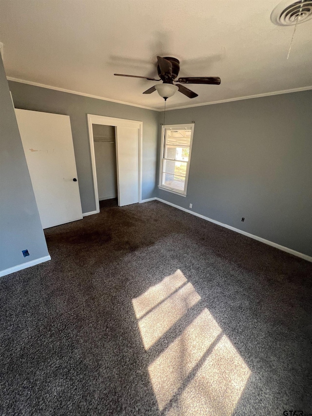 unfurnished bedroom with a closet, visible vents, ornamental molding, carpet flooring, and baseboards