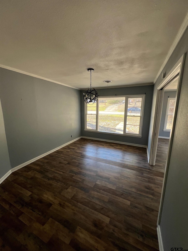 unfurnished dining area with a chandelier, ornamental molding, dark wood-style flooring, and baseboards