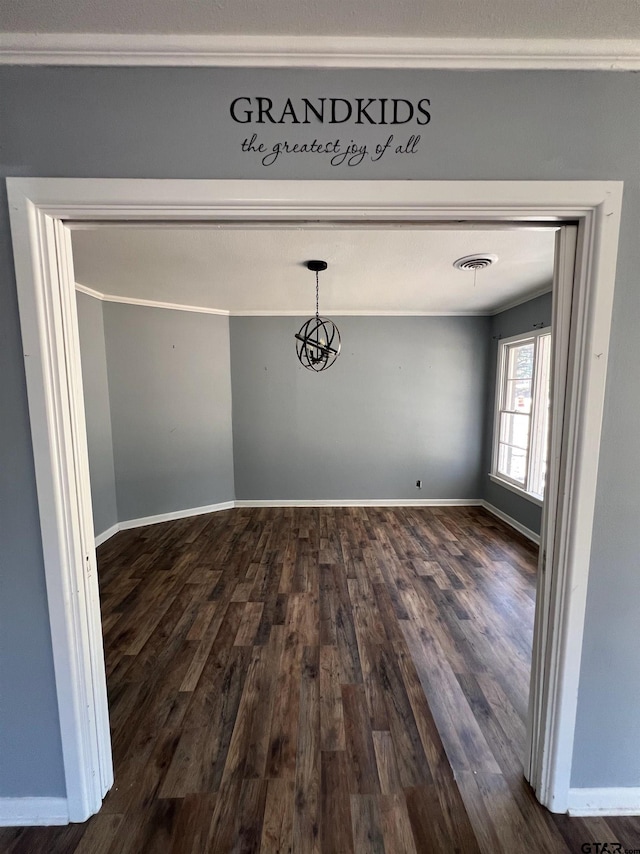 unfurnished dining area with dark wood-style floors, baseboards, visible vents, and ornamental molding