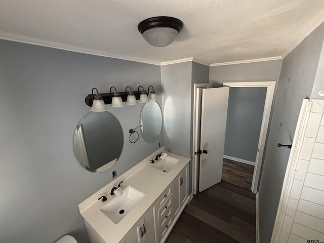 bathroom featuring a sink, double vanity, ornamental molding, and wood finished floors