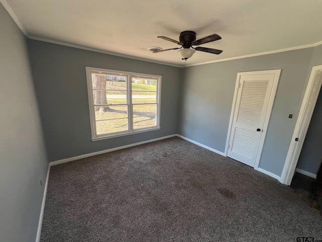 unfurnished bedroom with baseboards, dark carpet, and crown molding