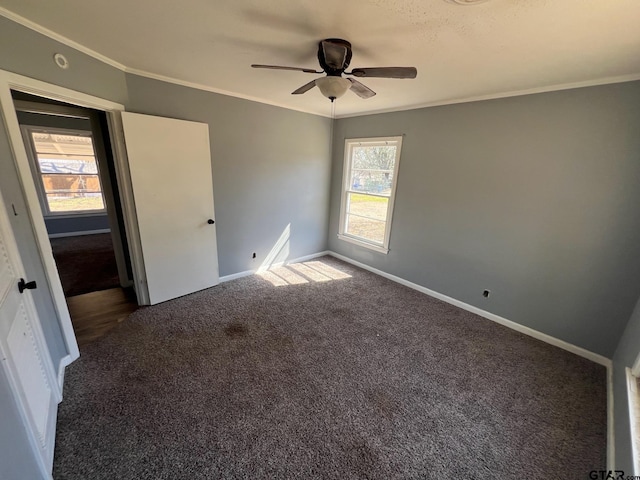 unfurnished bedroom with a ceiling fan, baseboards, crown molding, and carpet flooring