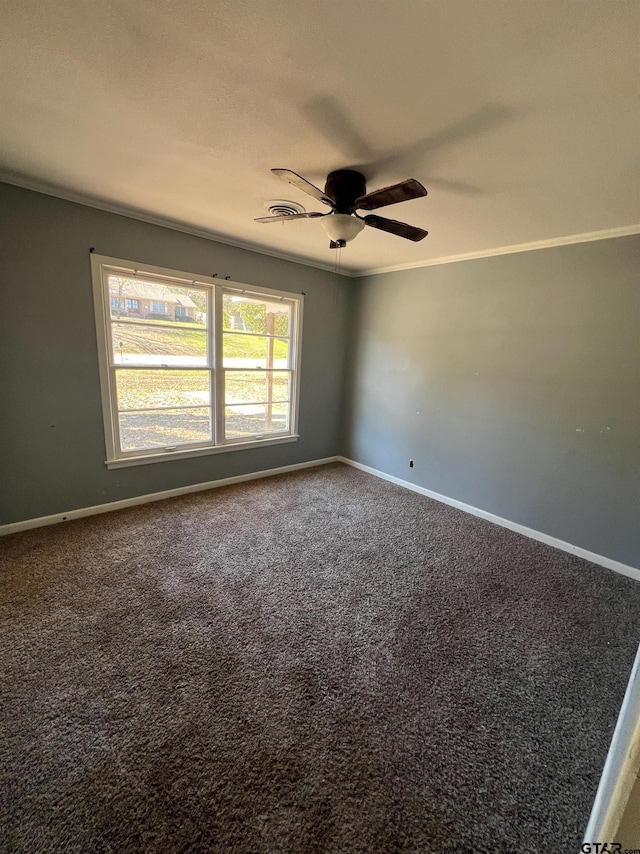 carpeted empty room with ornamental molding, a ceiling fan, and baseboards