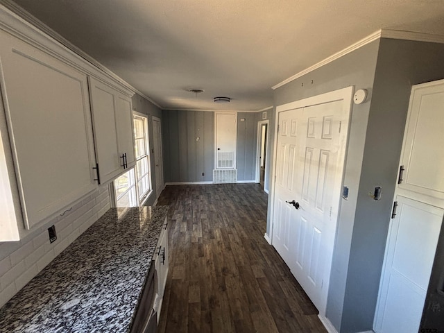 hall featuring ornamental molding, dark wood finished floors, and baseboards