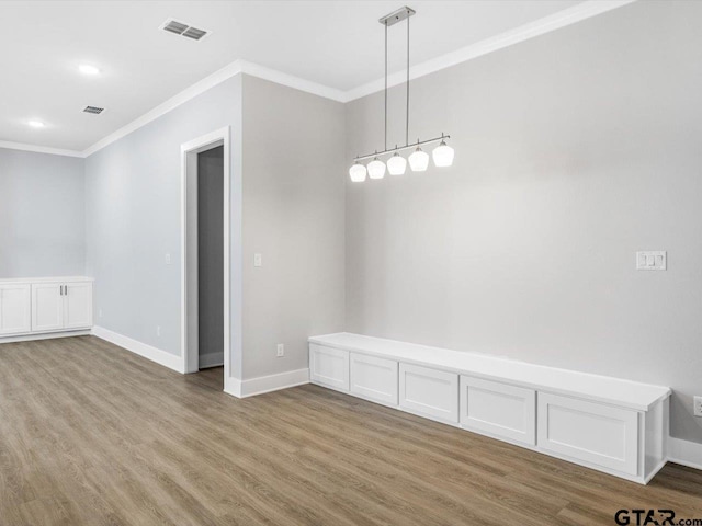 spare room featuring wood-type flooring and ornamental molding