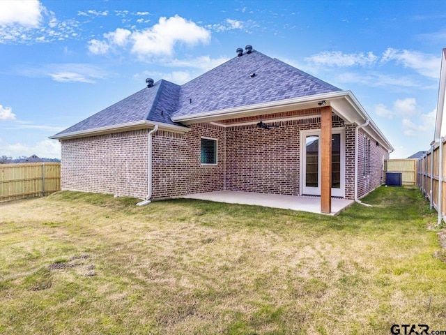 rear view of property featuring a yard, central AC, and a patio area