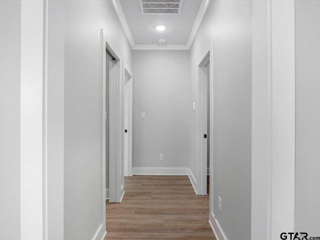 hall featuring crown molding and light hardwood / wood-style flooring