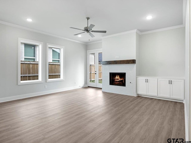 unfurnished living room with light hardwood / wood-style floors, ceiling fan, and ornamental molding