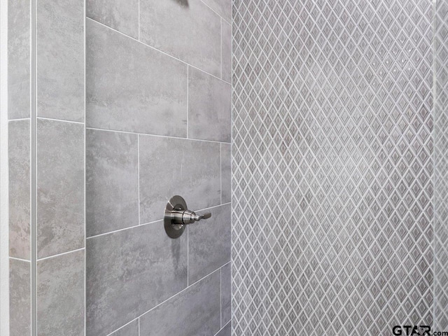 interior details featuring a tile shower