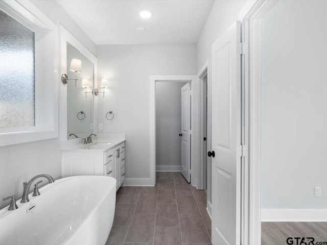 bathroom with a washtub and vanity