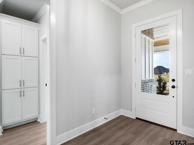 doorway featuring wood-type flooring and crown molding