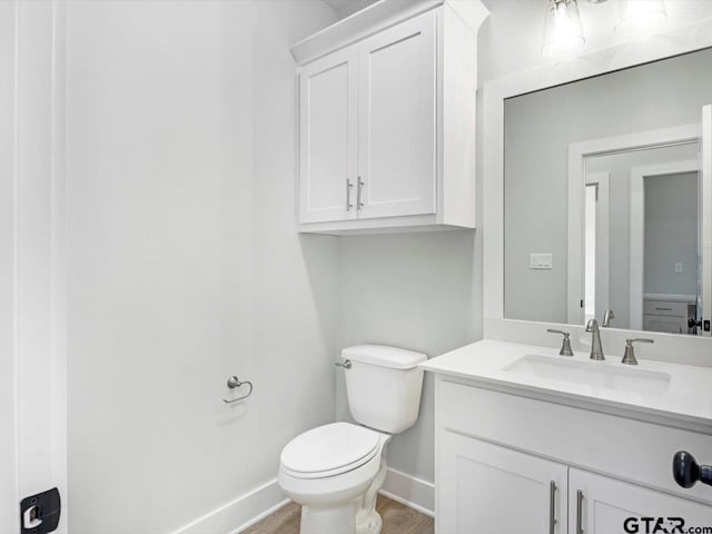 bathroom featuring hardwood / wood-style flooring, vanity, and toilet