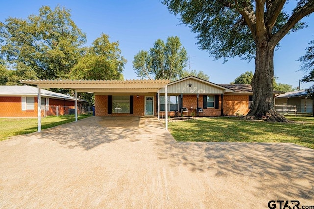 ranch-style home featuring a front lawn and a carport