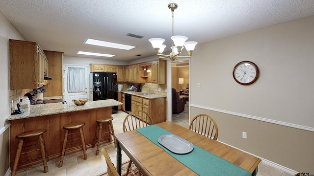 dining space featuring a chandelier, a textured ceiling, visible vents, and baseboards