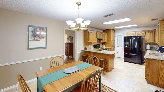 dining area featuring a chandelier, a textured ceiling, and visible vents