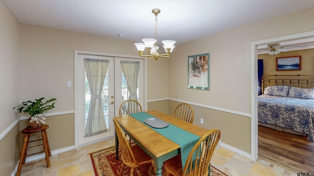 dining room featuring baseboards, french doors, a textured ceiling, and a notable chandelier