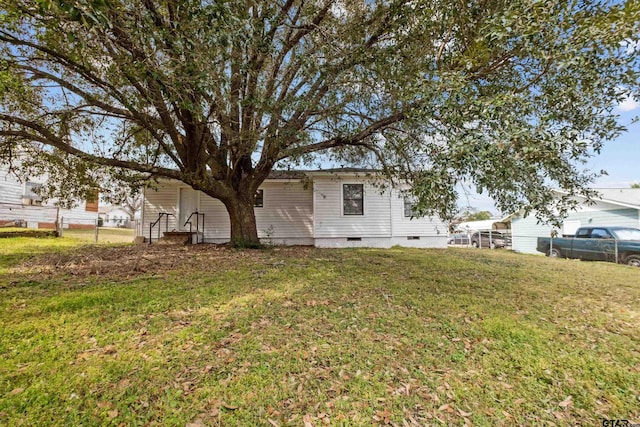 back of house with entry steps, crawl space, a yard, and fence