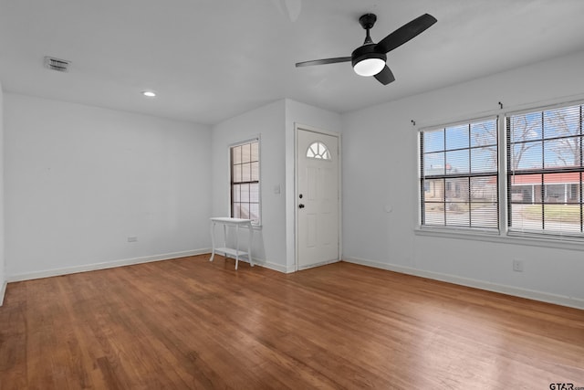 interior space with baseboards, visible vents, and wood finished floors