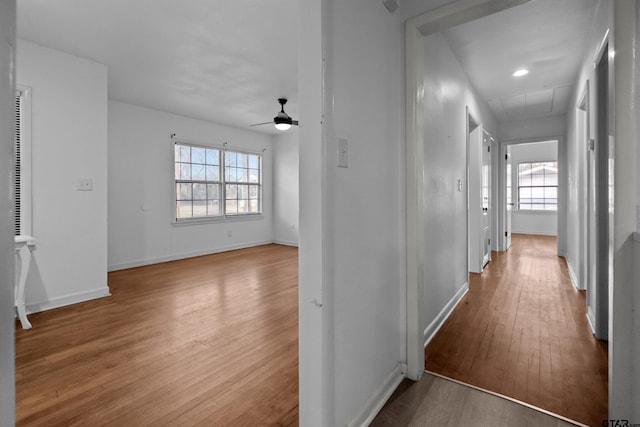 hall with attic access, baseboards, and wood finished floors