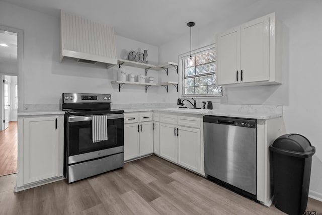 kitchen with open shelves, appliances with stainless steel finishes, white cabinets, a sink, and light wood-type flooring