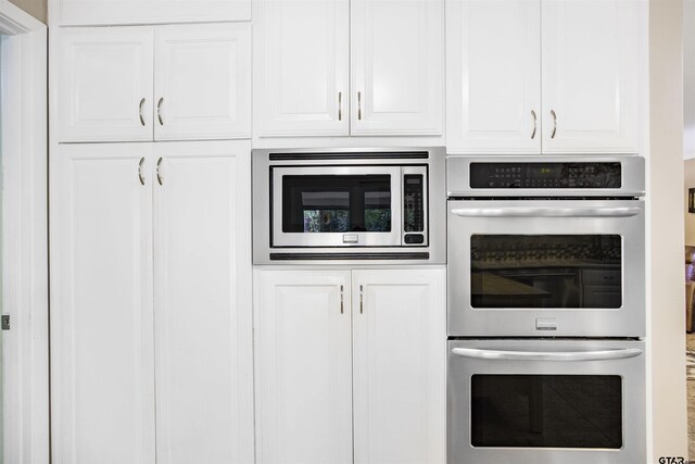 18058 Whispering Pines Rd, Flint, TX 75762 - kitchen with appliances with stainless steel finishes and white cabinetry