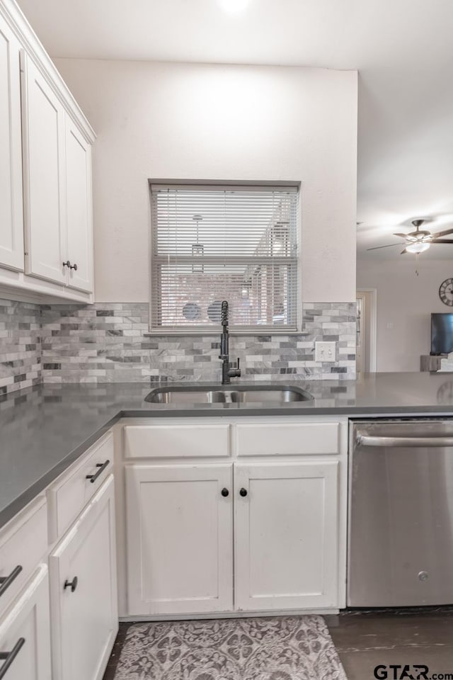 kitchen featuring sink, stainless steel dishwasher, white cabinets, ceiling fan, and backsplash