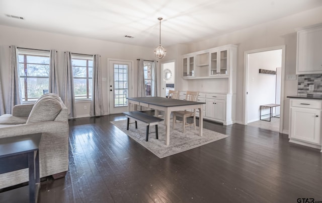 dining space with dark hardwood / wood-style floors and a notable chandelier