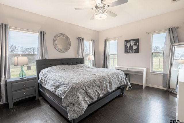 bedroom featuring multiple windows, ceiling fan, and dark hardwood / wood-style flooring