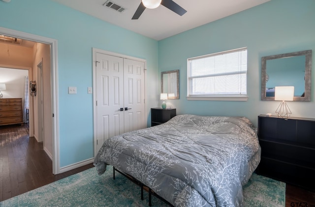 bedroom with dark hardwood / wood-style flooring, a closet, and ceiling fan