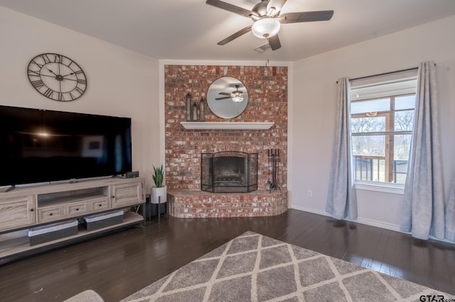 living room with a fireplace, dark hardwood / wood-style floors, and ceiling fan