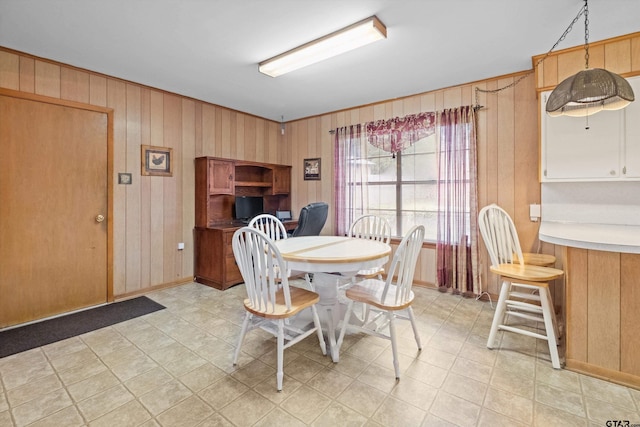 dining space featuring wooden walls