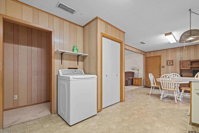 laundry room with wood walls and washer / dryer