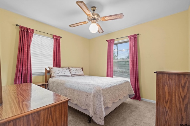 carpeted bedroom featuring multiple windows and ceiling fan