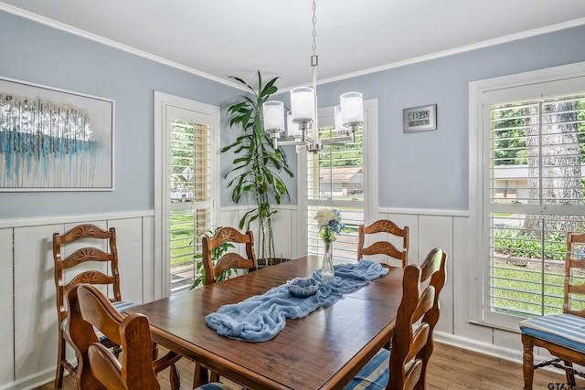 2600 Boldt Ave, Tyler, TX 75701 - dining room featuring crown molding, a wainscoted wall, wood finished floors, a decorative wall, and a chandelier