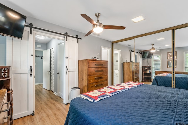 2600 Boldt Ave, Tyler, TX 75701 - bedroom featuring a barn door, light wood-style flooring, and a ceiling fan