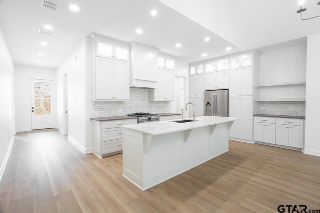 9244 Villas Ct, Tyler, TX 75703 - kitchen featuring appliances with stainless steel finishes, recessed lighting, light wood finished floors, decorative backsplash, and white cabinets
