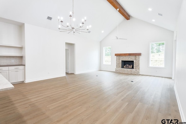 9244 Villas Ct, Tyler, TX 75703 - unfurnished living room with a chandelier, beam ceiling, healthy amount of natural light, light wood finished floors, and high vaulted ceiling