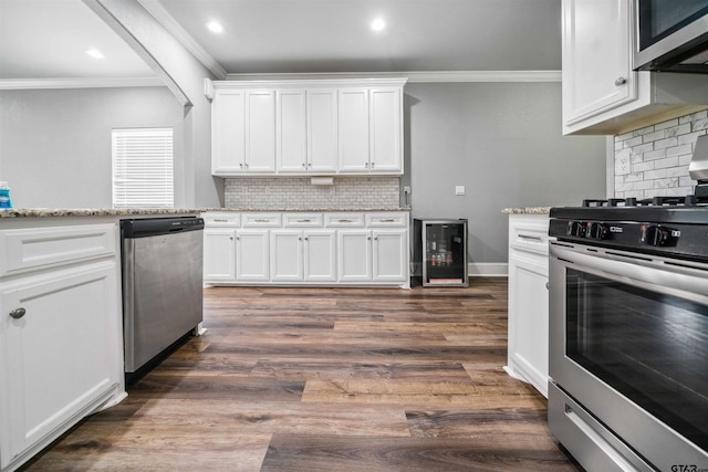 811 W 27th St, Tyler, TX 75702 - kitchen featuring stainless steel appliances, beverage cooler, ornamental molding, white cabinetry, and decorative backsplash