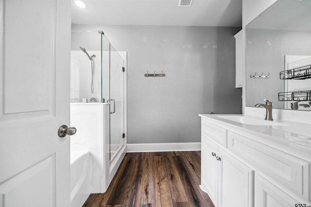 811 W 27th St, Tyler, TX 75702 - full bathroom with a shower stall, wood finished floors, baseboards, vanity, and recessed lighting