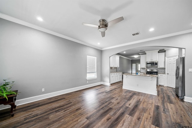 811 W 27th St, Tyler, TX 75702 - kitchen with appliances with stainless steel finishes, a ceiling fan, crown molding, arched walkways, and white cabinets
