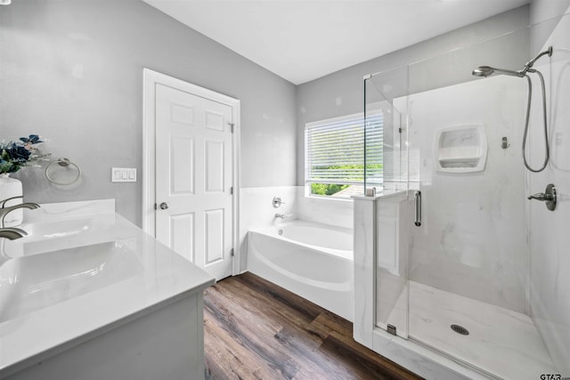 811 W 27th St, Tyler, TX 75702 - bathroom featuring wood finished floors, a stall shower, a garden tub, and double vanity