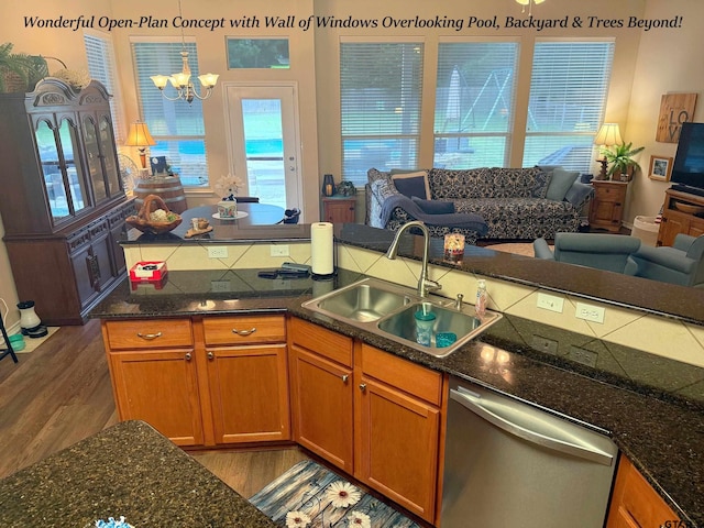 12260 Wild Horse, Tyler, TX 75706 - kitchen featuring open floor plan, wood finished floors, a chandelier, stainless steel dishwasher, and brown cabinets