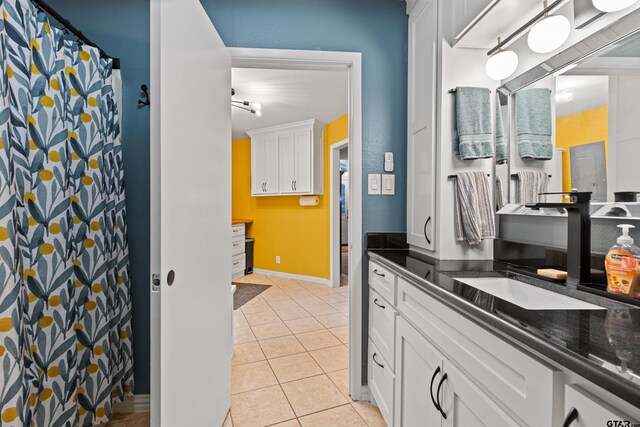 bathroom featuring vanity, baseboards, a shower with shower curtain, and tile patterned floors