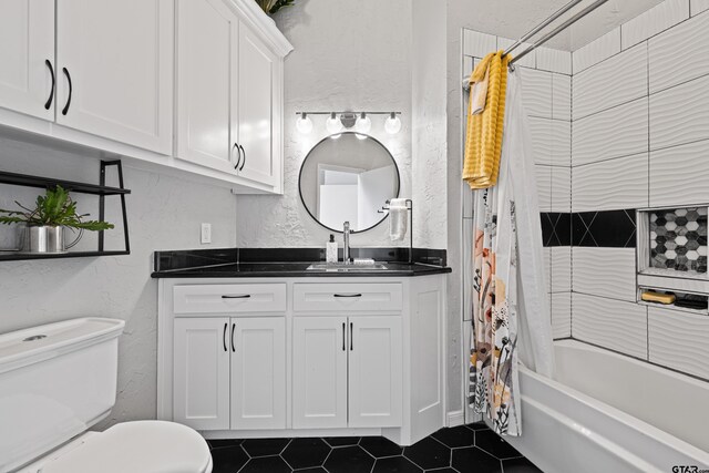 bathroom with shower / bath combination with curtain, tile patterned floors, vanity, toilet, and a textured wall