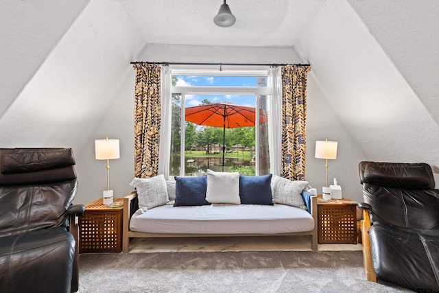 sitting room featuring carpet floors and vaulted ceiling