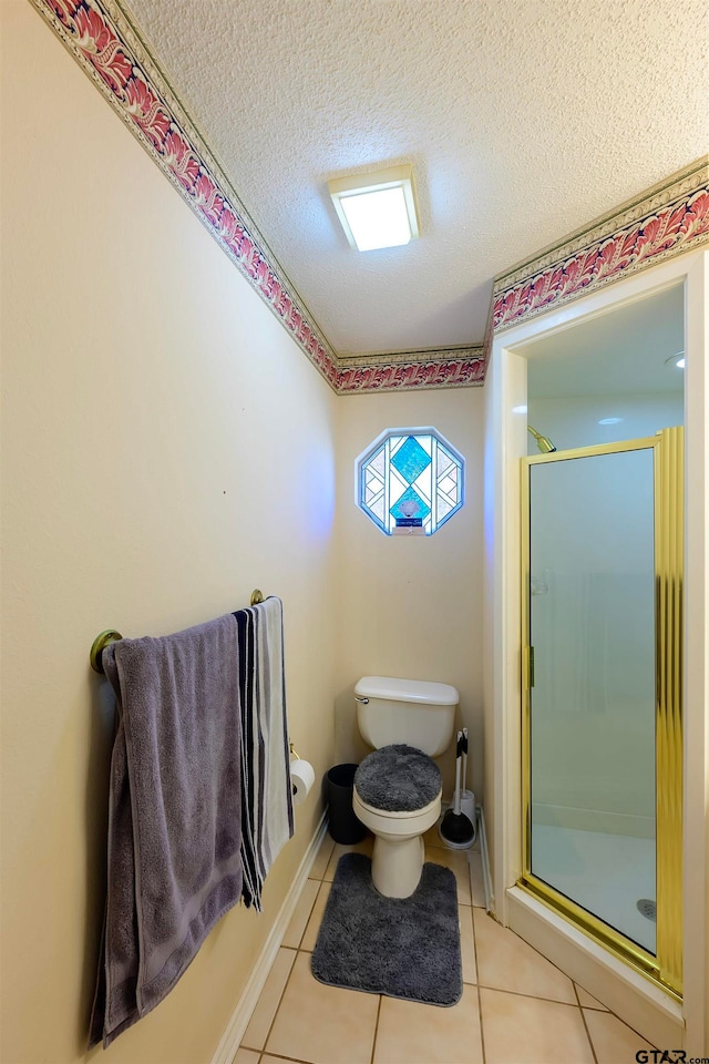 bathroom featuring a shower with door, tile patterned floors, toilet, and a textured ceiling