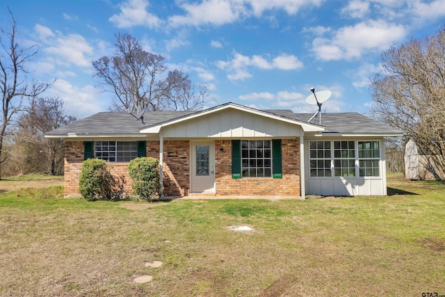 single story home featuring brick siding and a front yard