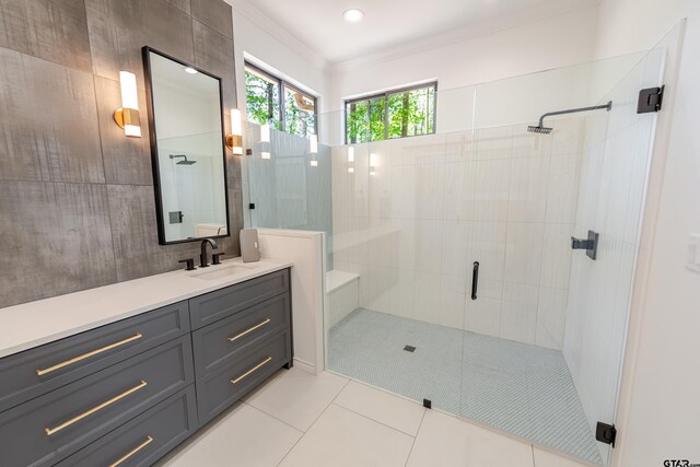 bathroom featuring crown molding, vanity, tile patterned floors, and a stall shower