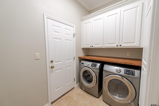 laundry room featuring washer and dryer, cabinet space, and light tile patterned floors